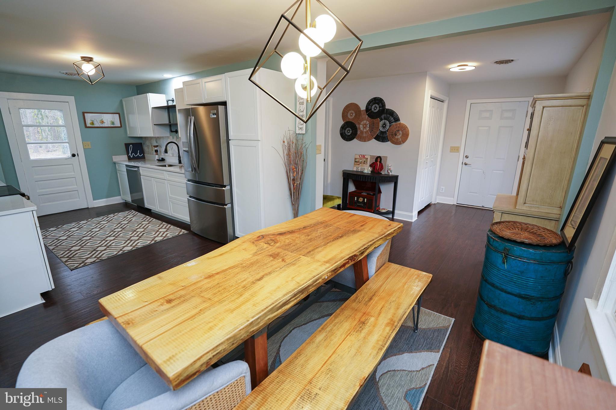 a living room with stainless steel appliances furniture a rug and a fireplace