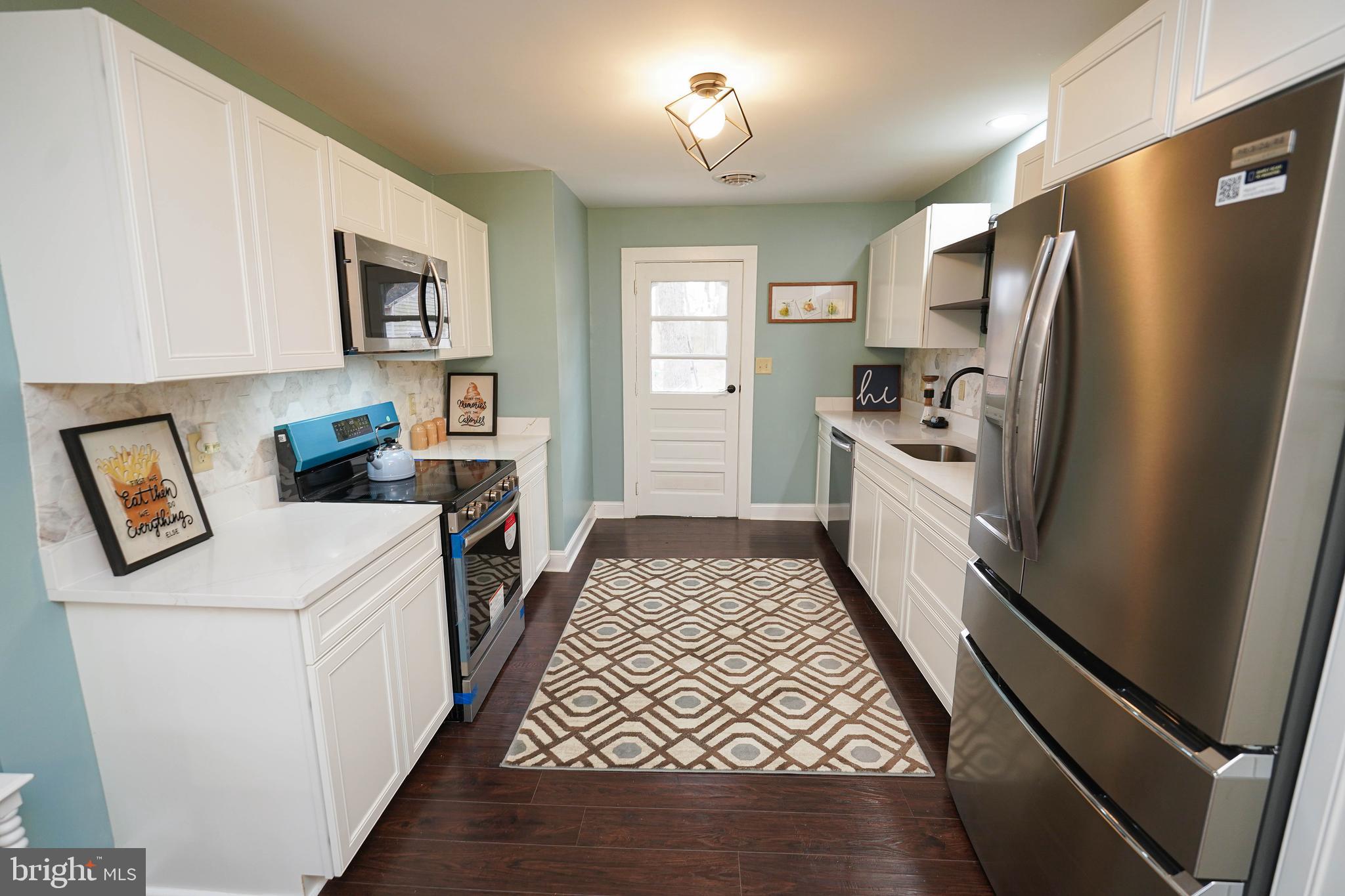 3493 Meadow Bridge Road Eden, MD 21822 - Photo 12 of 36 a kitchen with stainless steel appliances a refrigerator a stove a sink a dining table and chairs