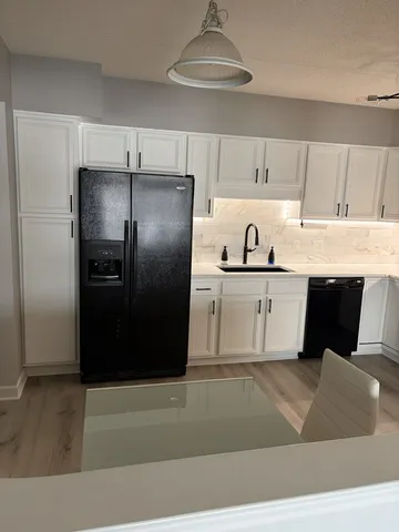 a kitchen with stainless steel appliances granite countertop a refrigerator and a sink