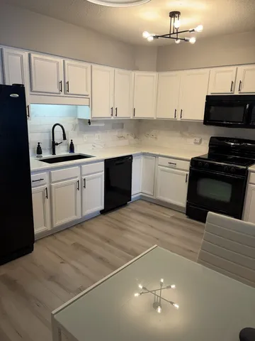 a kitchen with kitchen island granite countertop a sink cabinets and stainless steel appliances