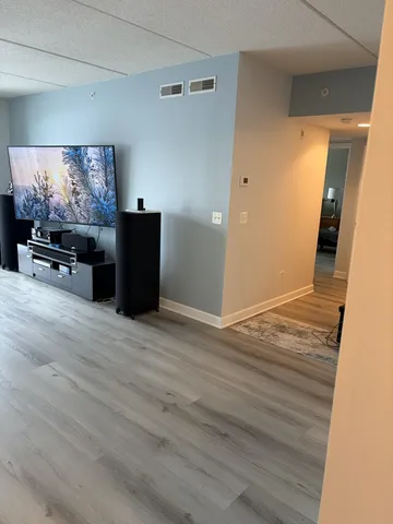 a view of a livingroom with wooden floor and furniture