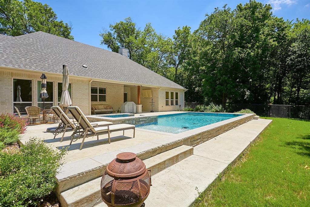 358 Glade Valley Road Azle, TX 76020 - Photo 1 of 35 Rectangular swimming pool with integrated spa and stone surround, accompanied by an expansive concrete patio