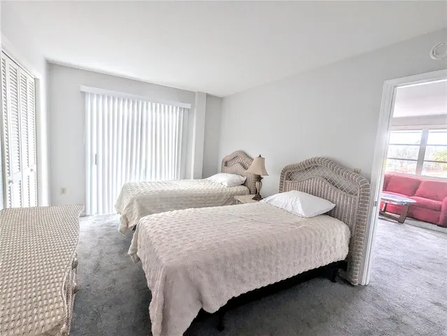 a bedroom with two beds and a large window