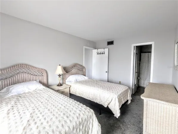 a bedroom with two beds and a lamp