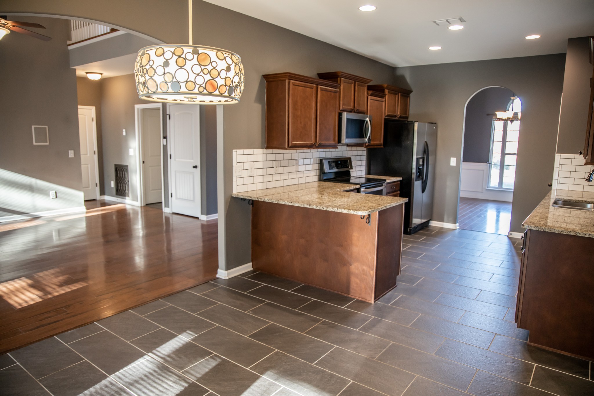 2030 Lincoln Road Spring Hill, TN 37174 - Photo 5 of 29 a view of a kitchen with granite countertop a stove top oven a sink dishwasher and a dining table with wooden floor