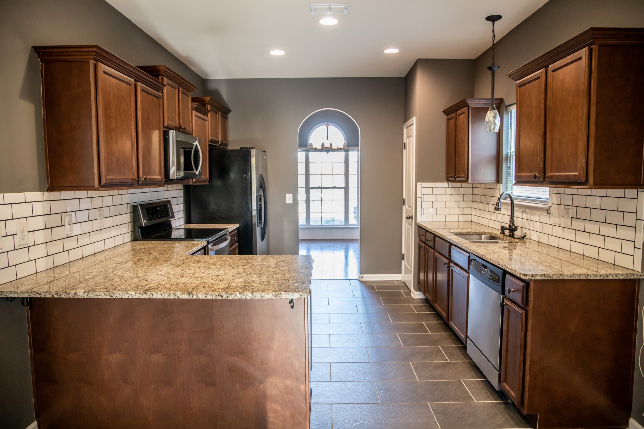 2030 Lincoln Road Spring Hill, TN 37174 - Photo 6 of 29 a large kitchen with kitchen island granite countertop a sink a stove and a wooden cabinets