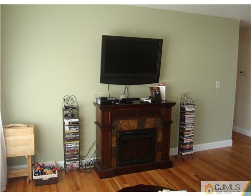 8 Yale Road Old Bridge, NJ 08859 - Photo 2 of 14 a room with a fireplace and a flat screen tv