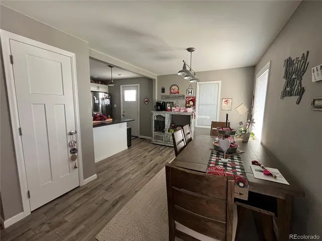 a room with furniture a flat screen tv and a refrigerator