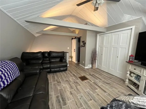 a living room with furniture a flat screen tv and a couch