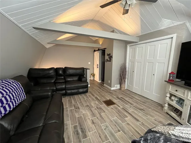 a living room with furniture a flat screen tv and a couch