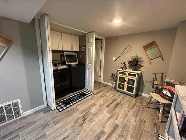 a view of a kitchen with wooden floor and electronic appliances