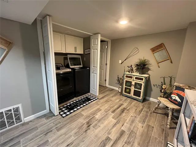 a view of a kitchen with wooden floor and electronic appliances