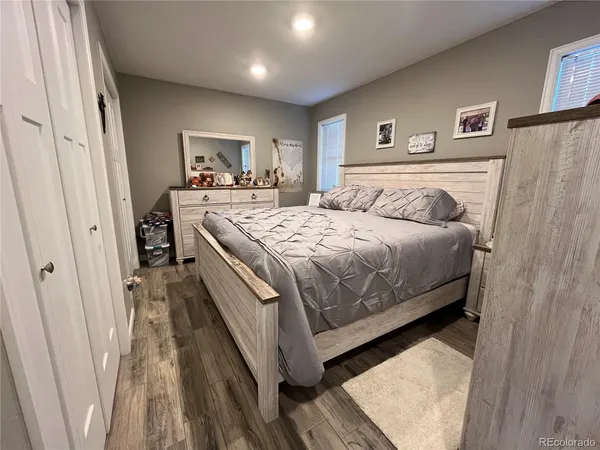 a bedroom with a large bed and a wooden floor