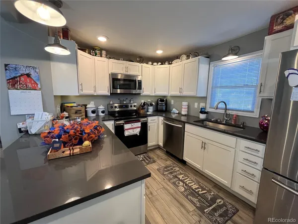 a kitchen with stainless steel appliances a sink a stove top oven a counter space and cabinets