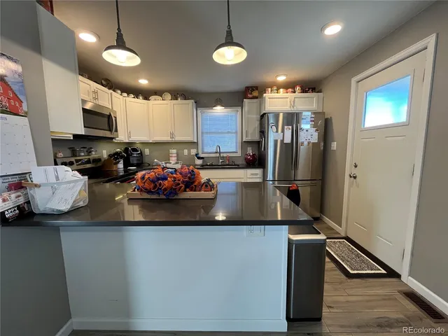 a kitchen with kitchen island granite countertop a sink appliances and cabinets