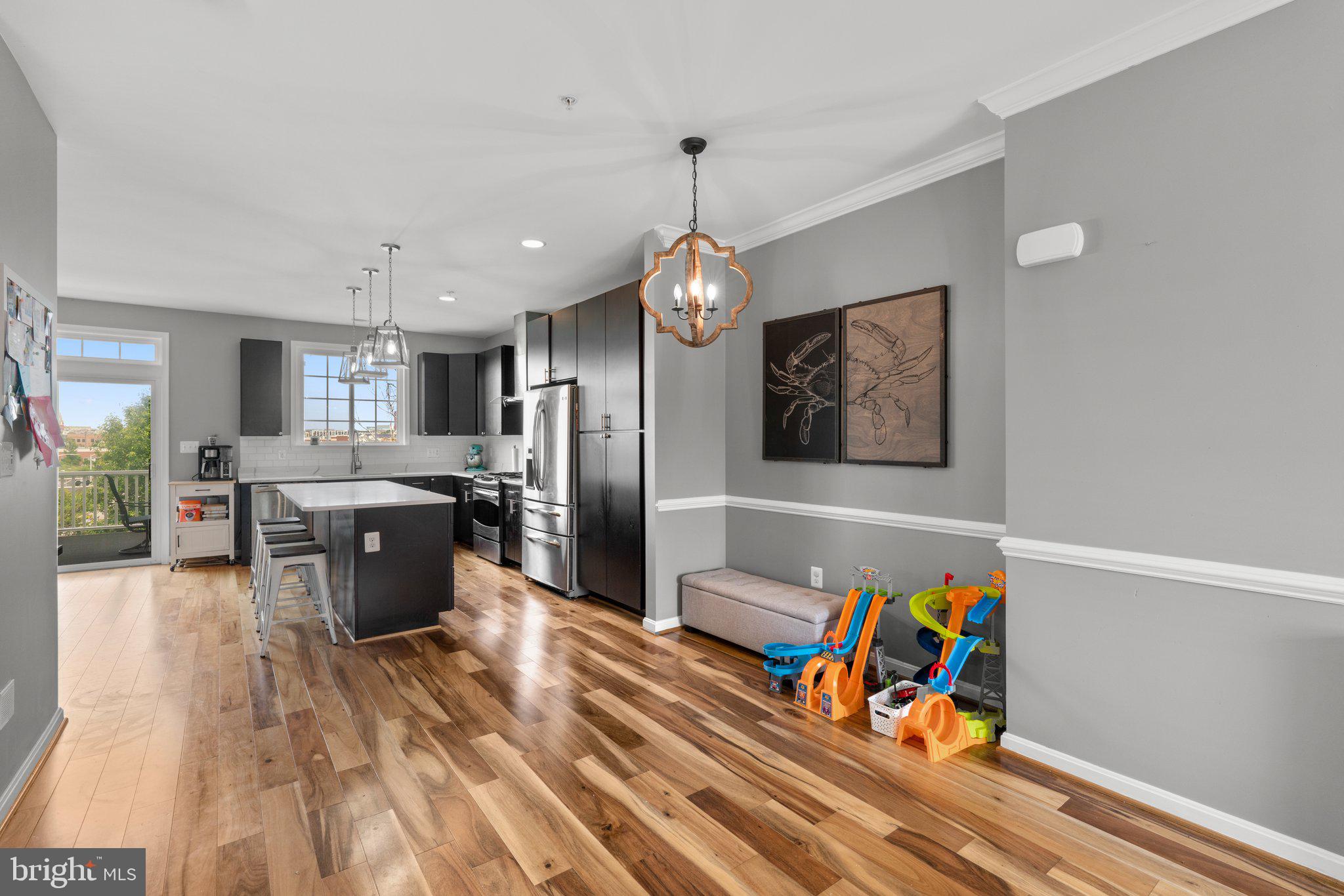 1338 Lowman Street Baltimore, MD 21230 - Photo 21 of 72 a large kitchen with stainless steel appliances granite countertop a refrigerator a sink dishwasher a dining table and chairs with wooden floor