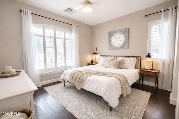 a bedroom with a bed and wooden floor