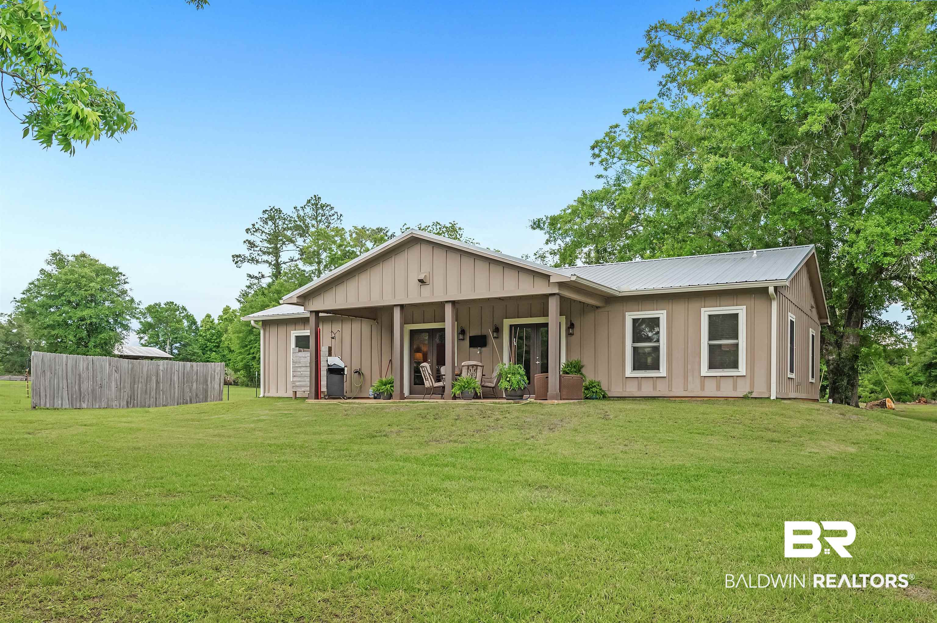 13827 County Road 83 Elberta, AL 36530 - Photo 7 of 38 View of front of home with board and batten siding, a front yard, and metal roof