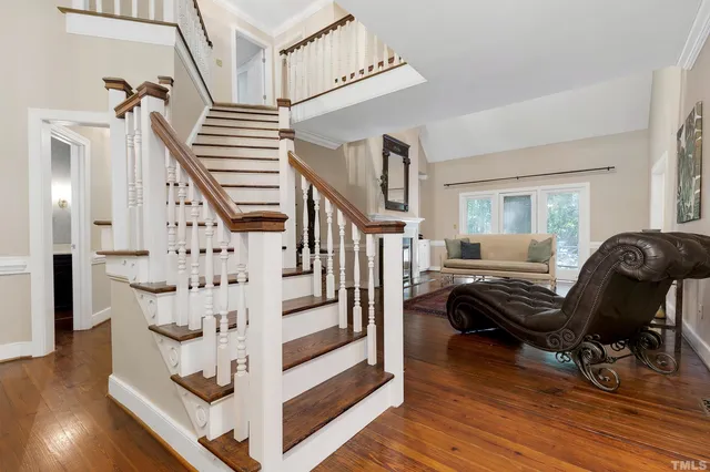 a view of a hallway with wooden floor and staircase