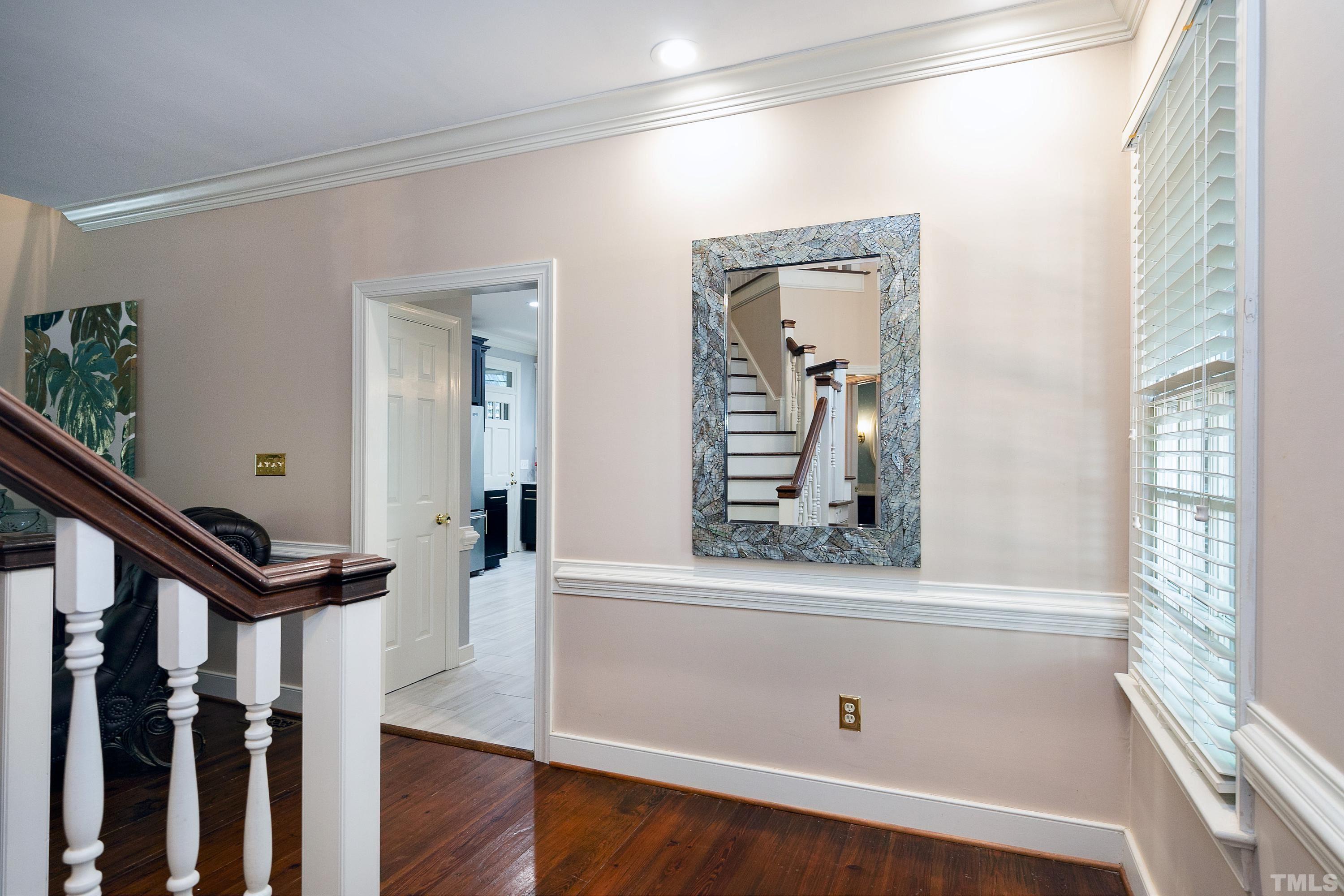 113 Palace Green Cary, NC 27518 - Photo 5 of 32 a view of a hallway with wooden floor and staircase