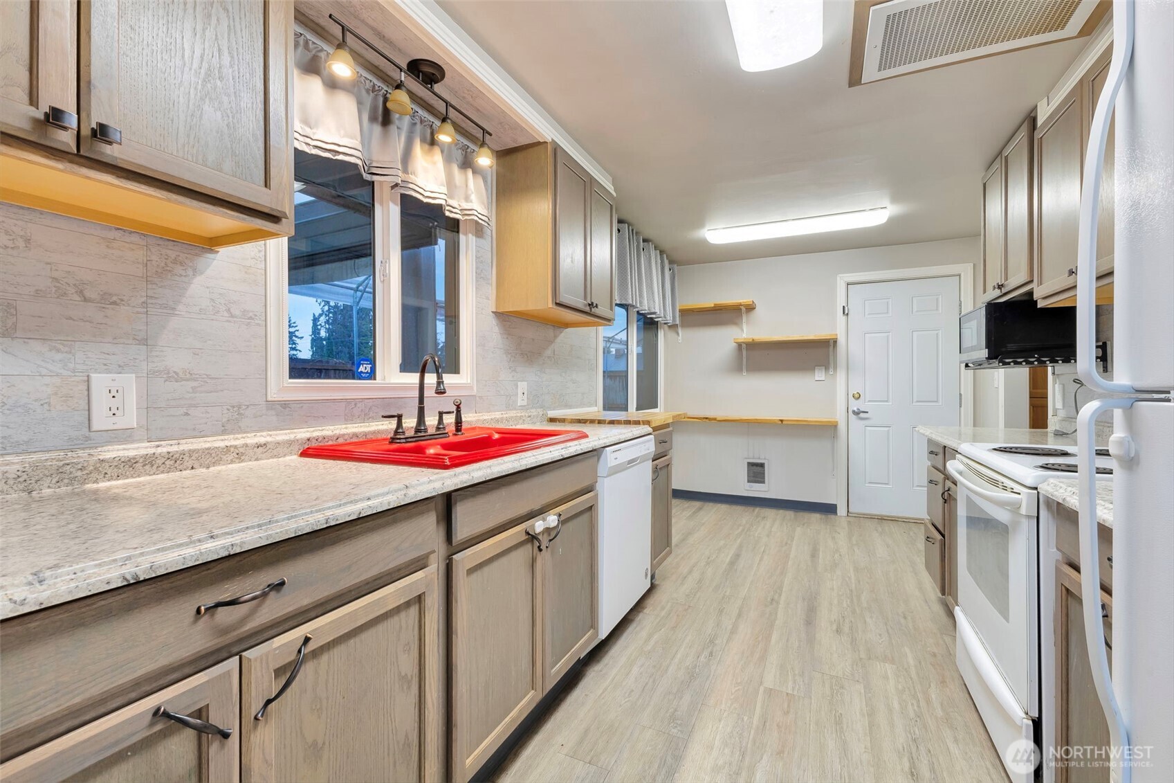 10915 Davisson Road Southwest Lakewood, WA 98499 - Photo 11 of 29 a kitchen with stainless steel appliances granite countertop a sink and a refrigerator