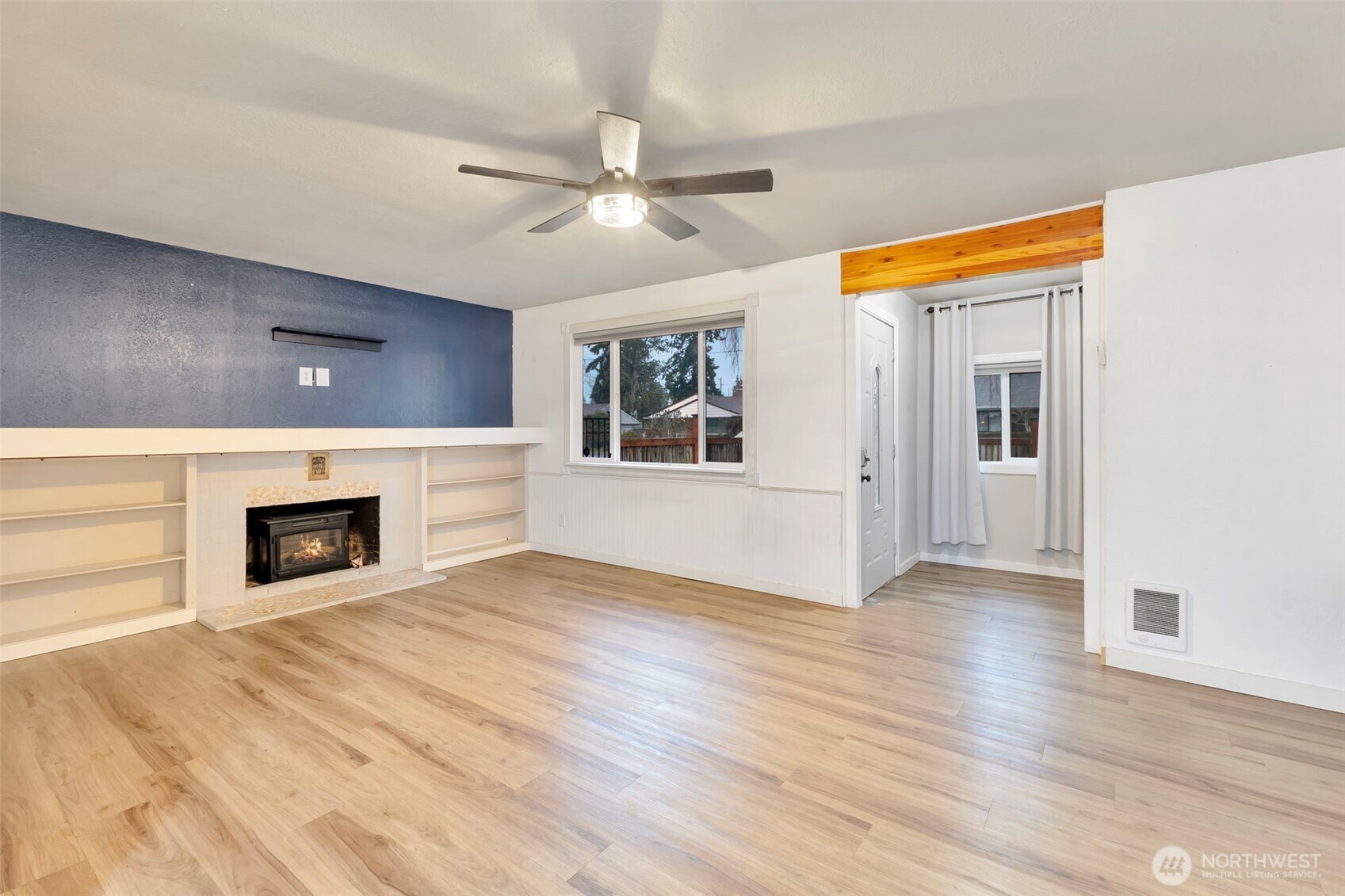 10915 Davisson Road Southwest Lakewood, WA 98499 - Photo 8 of 29 a view of a livingroom with a fireplace a ceiling fan and windows