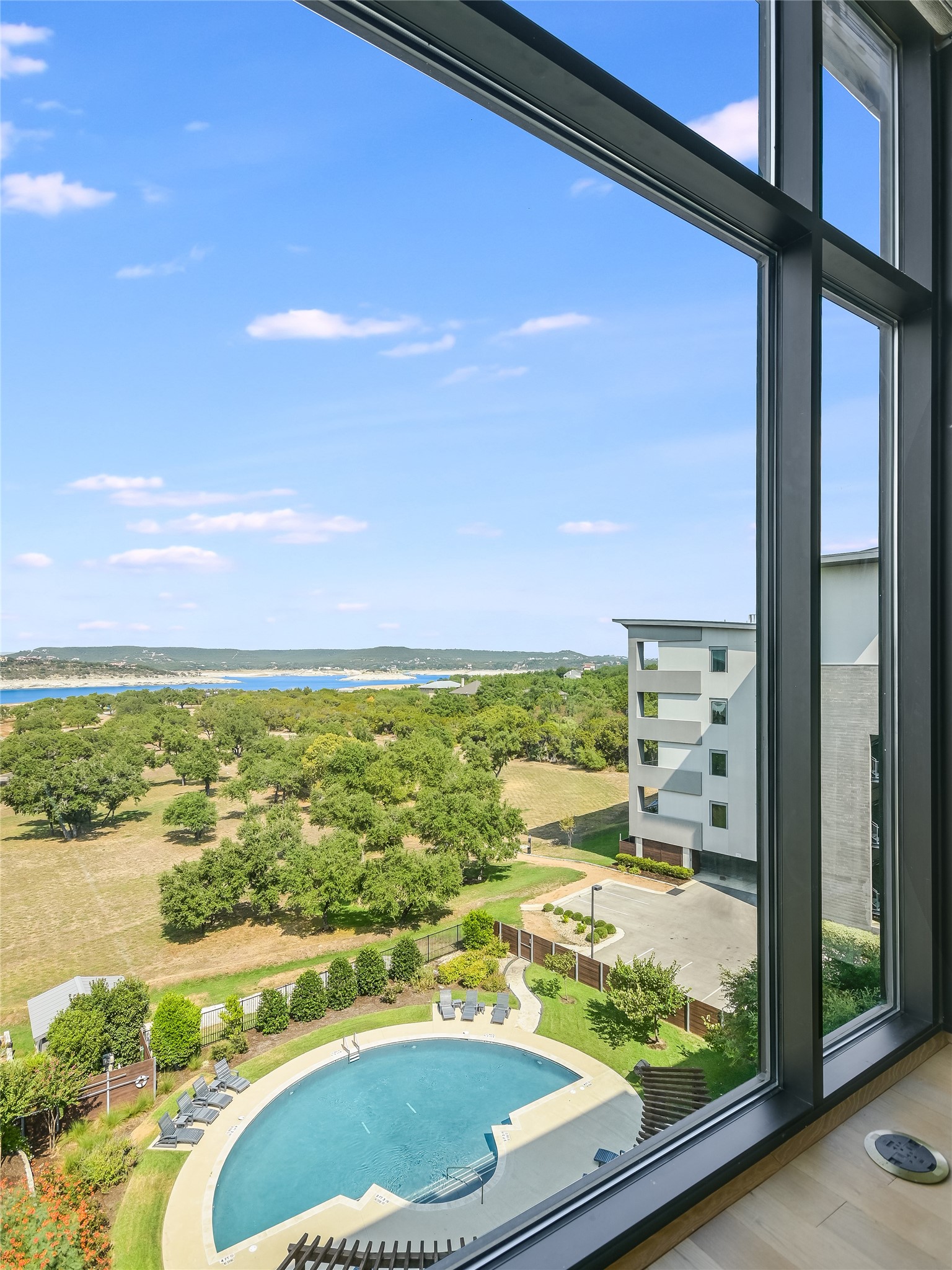 5921 Hiline Road, Unit 1501 Austin, TX 78734 - Photo 13 of 38 Striking views from the owner's bedroom. Note the electrical floor plug. Floor to ceiling windows come complete with automatic powered roller shades for added privacy.