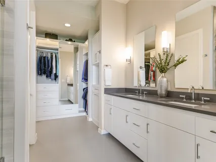 a bathroom with double vanity and a mirror