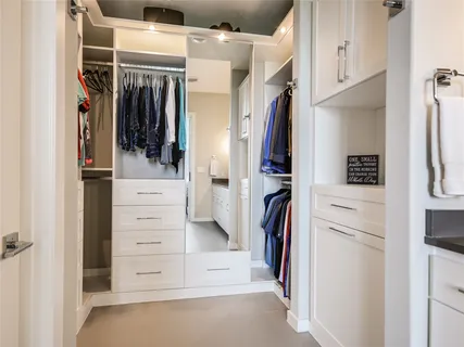 a view of walk in closet with clothes and shoes