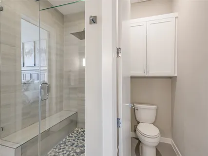 a bathroom with a toilet and a shower
