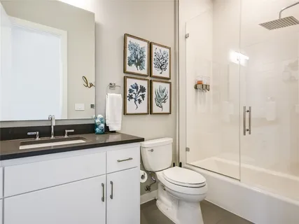 a bathroom with a granite countertop toilet sink and a mirror