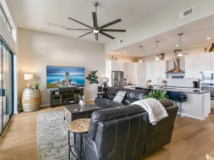 a living room with furniture a flat screen tv and kitchen view