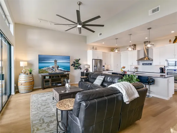 a living room with furniture a flat screen tv and kitchen view