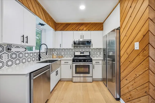 a kitchen with stainless steel appliances granite countertop a sink and a stove