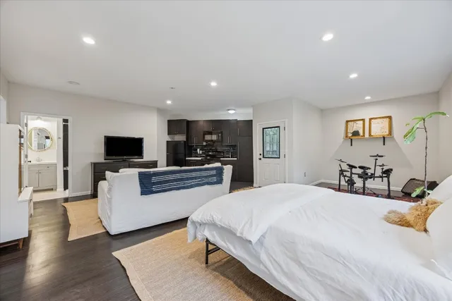 a large bedroom with a bed and a flat screen tv