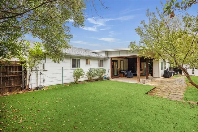 a view of a house with a yard and tree s