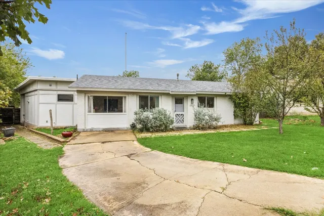 a front view of a house with a garden and yard