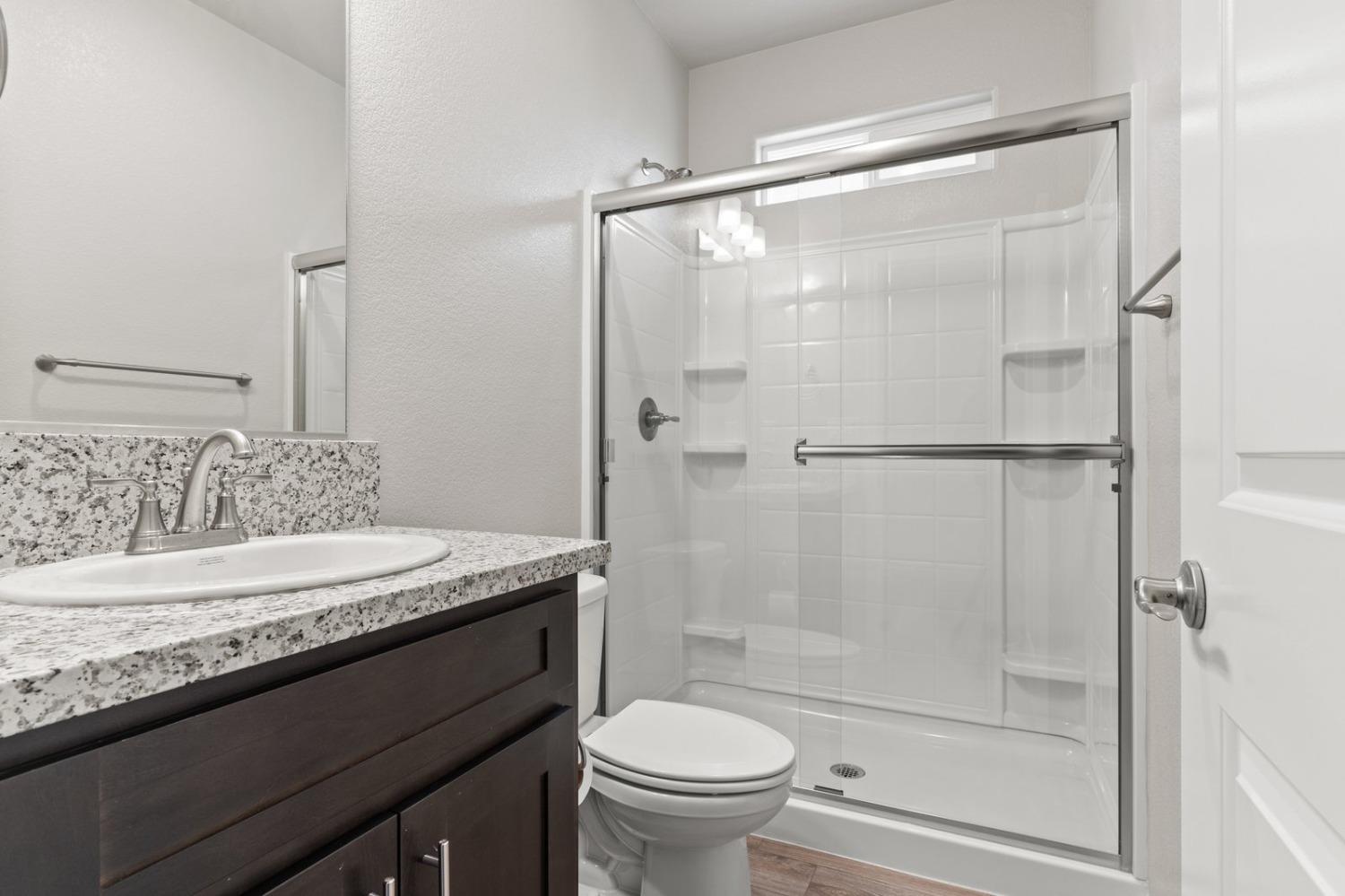 3916 Wickman Loop Rocklin, CA 95677 - Photo 19 of 40 a bathroom with a granite countertop sink toilet and shower