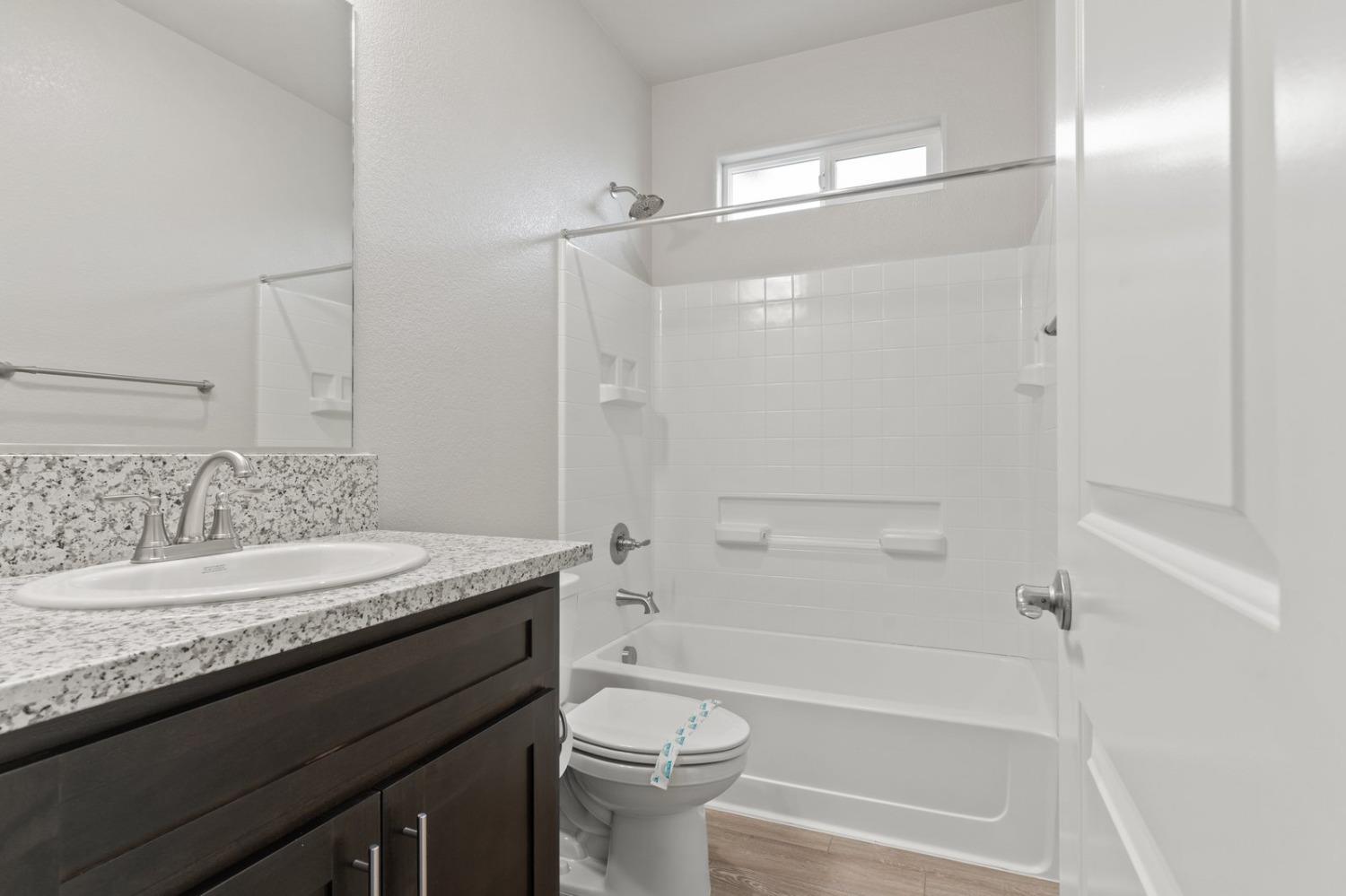 3916 Wickman Loop Rocklin, CA 95677 - Photo 29 of 40 a bathroom with a granite countertop sink a toilet and shower