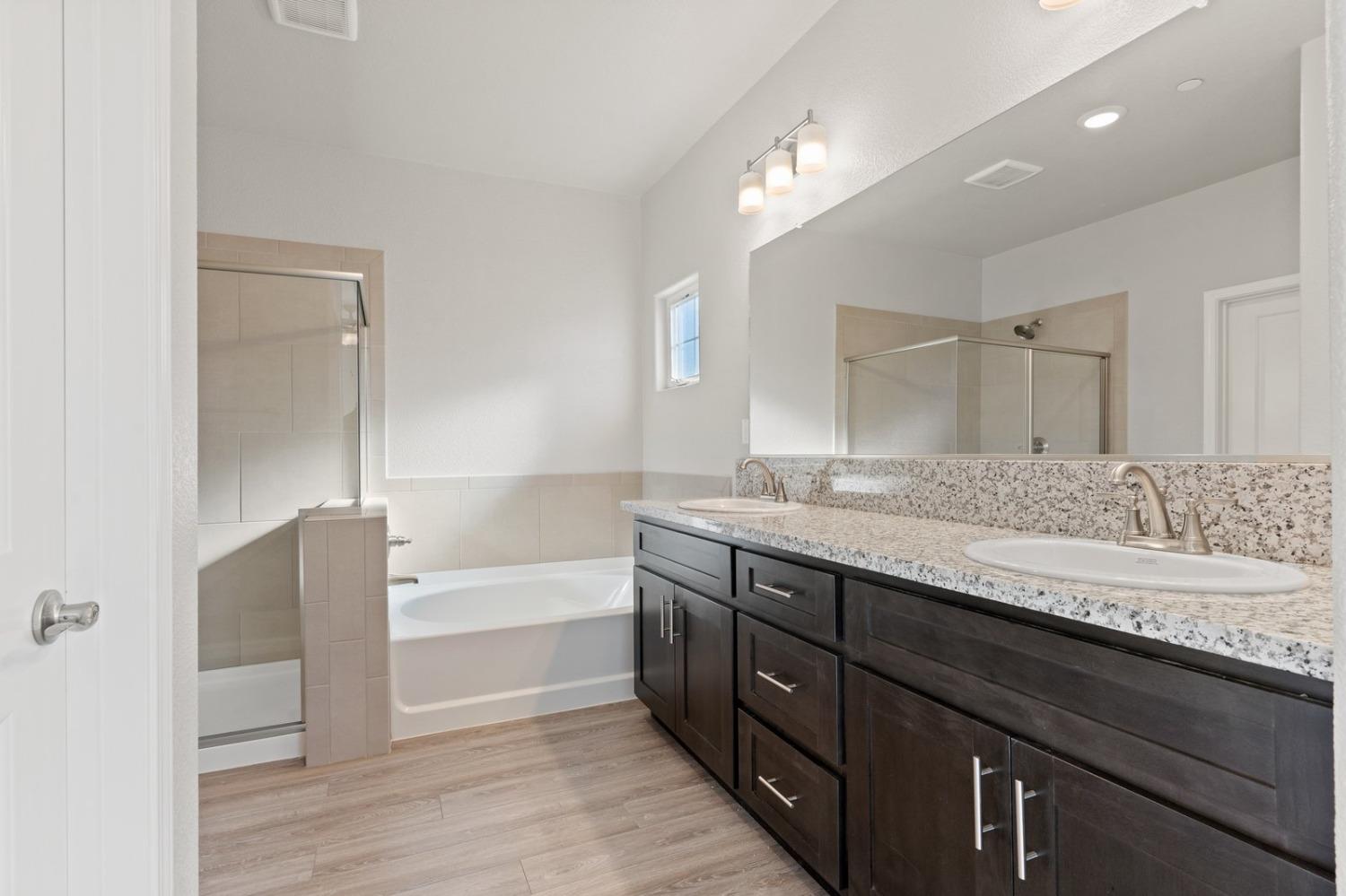 3916 Wickman Loop Rocklin, CA 95677 - Photo 34 of 40 a bathroom with a granite countertop bathtub sink double and mirror