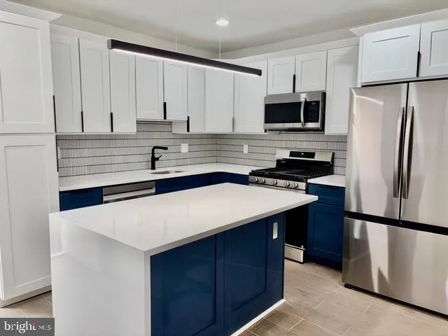 a kitchen with stainless steel appliances a refrigerator sink and cabinets