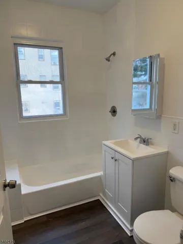 a bathroom with a granite countertop toilet a sink and bathtub