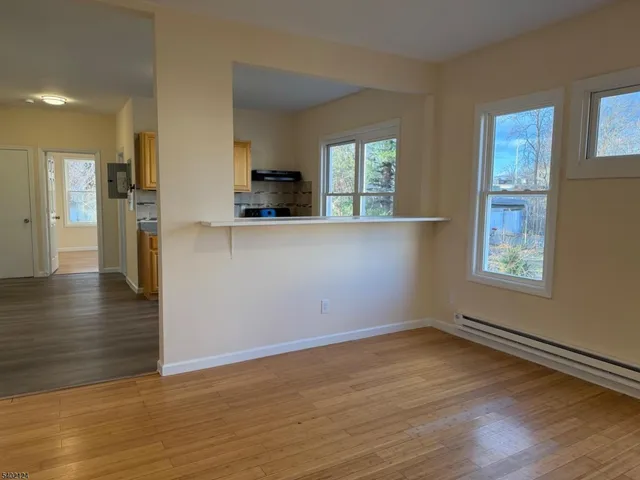 a view of a kitchen with wooden floor and a window