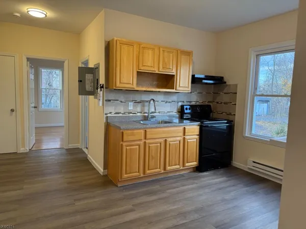 a kitchen with stainless steel appliances granite countertop a sink stove and wooden floor