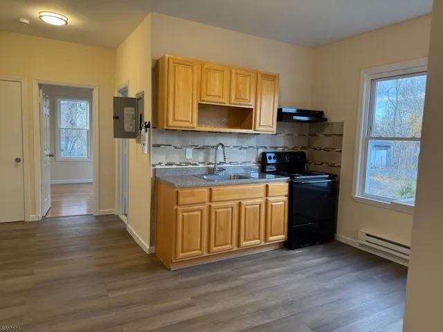 a kitchen with stainless steel appliances granite countertop a sink stove and wooden floor