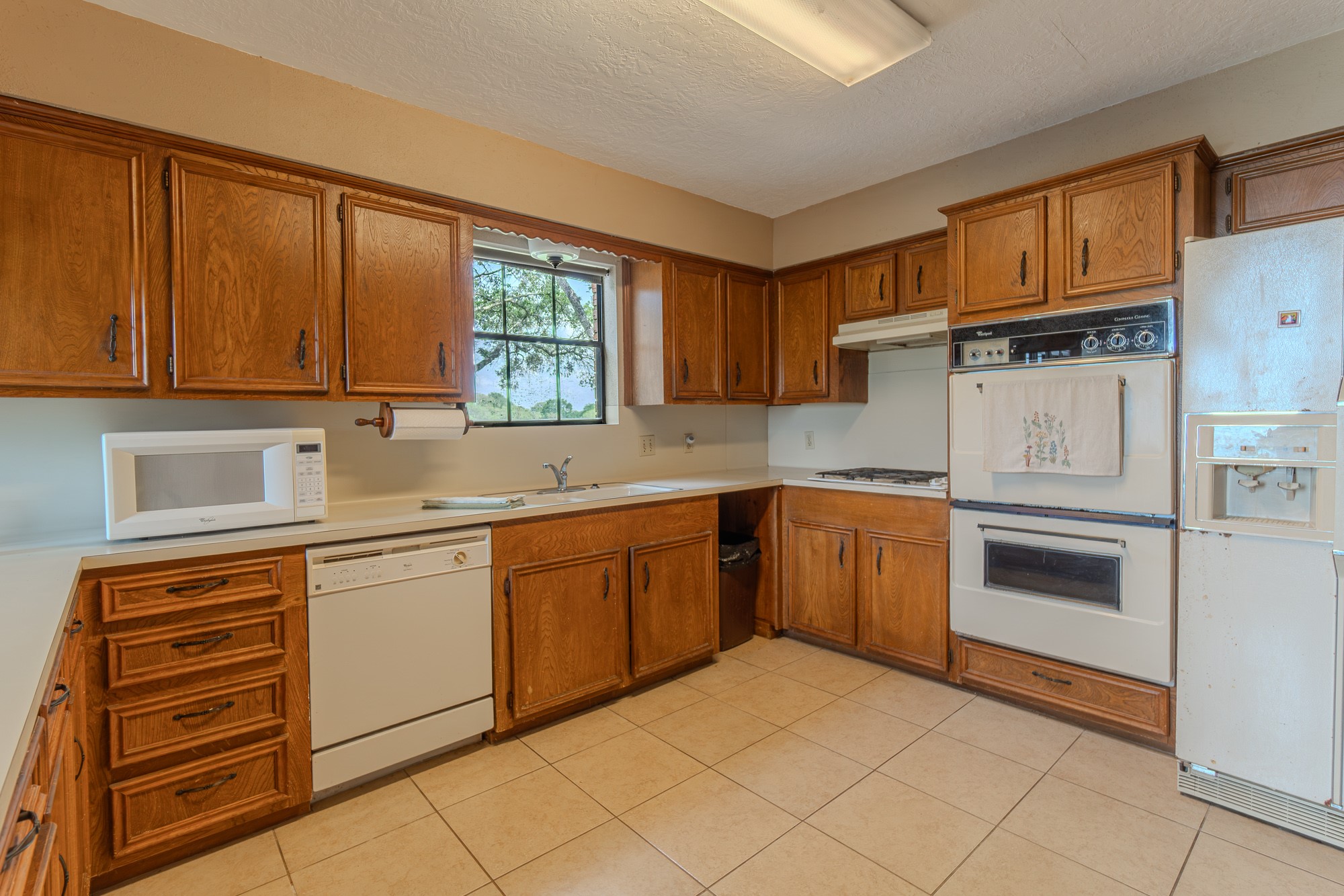2745 Holub Road Schulenburg, TX 78956 - Photo 30 of 40 a kitchen with granite countertop white cabinets and white appliances