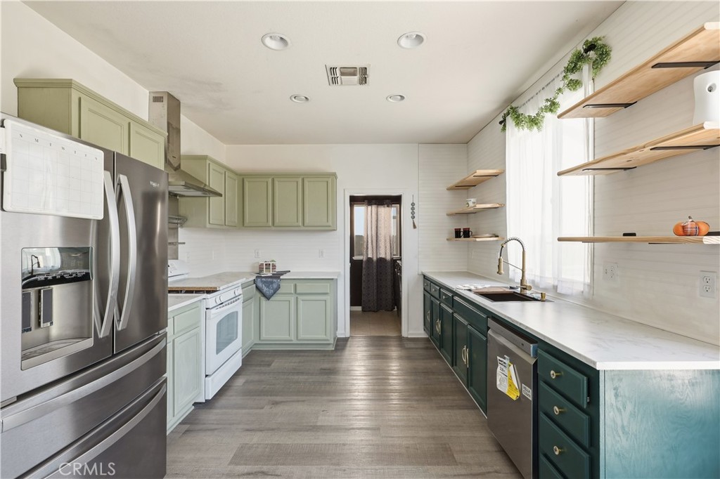84 Jack Court Merced, CA 95341 - Photo 12 of 34 a kitchen with stainless steel appliances a sink dishwasher a refrigerator and a stove with wooden floor