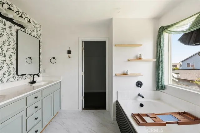a bathroom with a tub sink and mirror