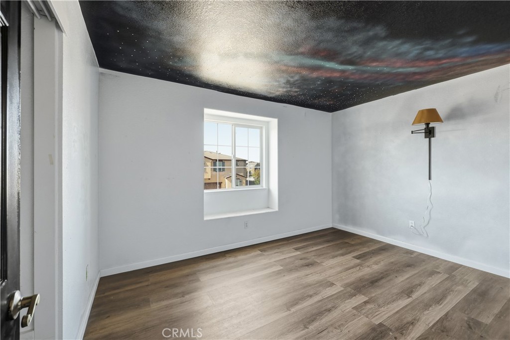 84 Jack Court Merced, CA 95341 - Photo 27 of 34 an empty room with wooden floor and windows