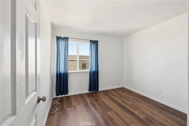 an empty room with wooden floor and a window